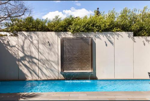 a swimming pool with a fence and a fountain at Luxurious Townhouse Retreat in Prestigious Brighton in Melbourne