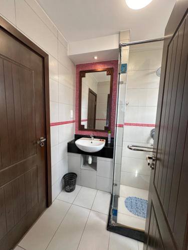 a bathroom with a sink and a shower and a mirror at Almasi beach house in Mtwapa