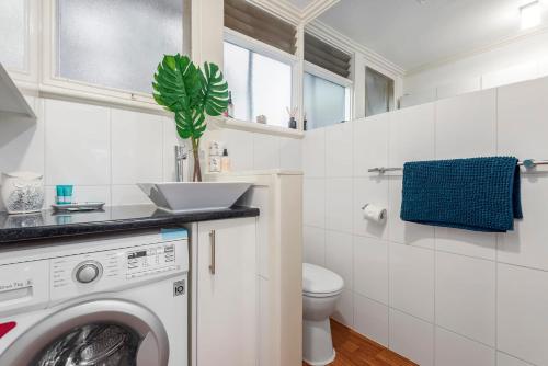 a white bathroom with a washing machine in it at MOANA I Walk to Beach & River in Ocean Grove