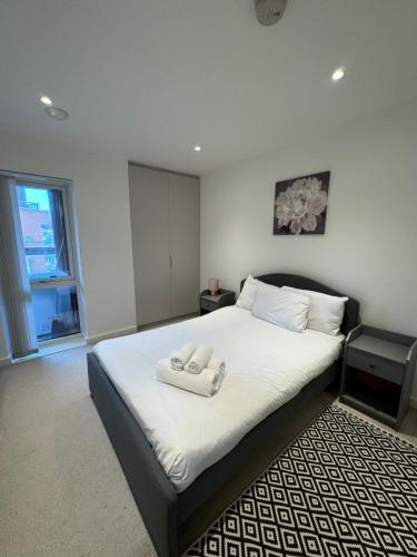 a bedroom with a bed with two towels on it at Two bedroom apartment with 2 bathroom in London