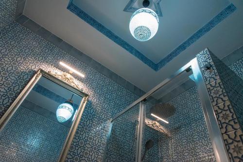 a bathroom with a shower and a mirror and lights at Casa de la Judería Doña Pilar in Seville