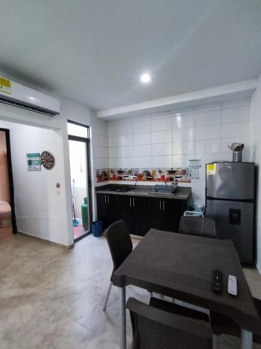 a large kitchen with a table and a refrigerator at Cabaña en condominio frente al mar #10 in Tolú