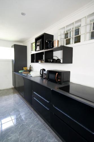 una cucina con armadi neri e piano di lavoro nero di holiday home 2 bed a DʼArbeau