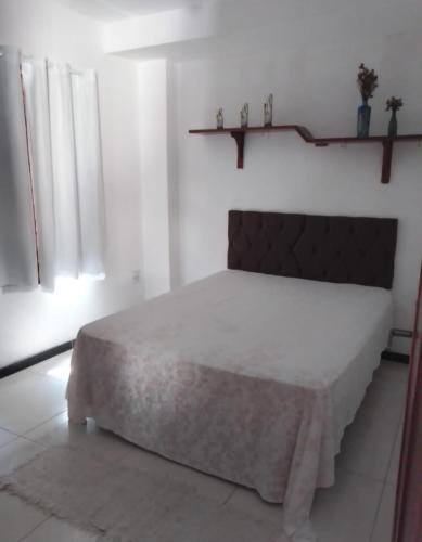 a white bedroom with a bed in a room at Alice in Porto Seguro