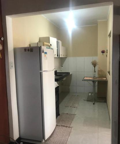 a small kitchen with a refrigerator in a room at Alice in Porto Seguro
