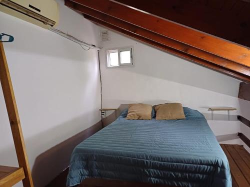 ein Schlafzimmer mit einem Bett mit zwei Kissen darauf in der Unterkunft Departamento Juana Azurduy in Merlo
