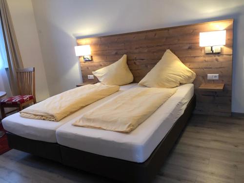 a bedroom with a large bed with two pillows at Gasthaus Hotel Löffelschmiede in Hinterzarten