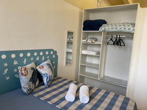 Un pequeño dormitorio con una cama con toallas. en Casa Temporada, en Florianópolis