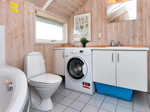 a bathroom with a washing machine and a toilet at Four-Bedroom Holiday home in Rønde 1 in Rønde