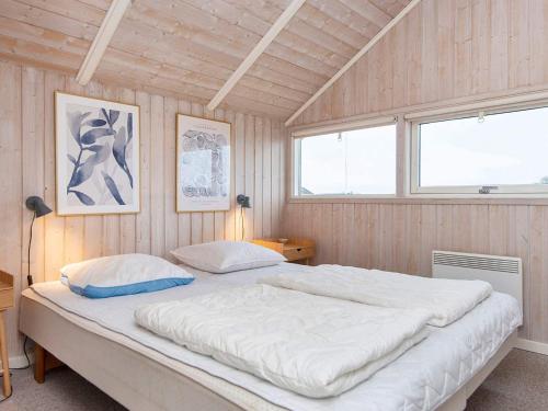 a large bed in a room with wooden walls at Four-Bedroom Holiday home in Rønde 1 in Rønde
