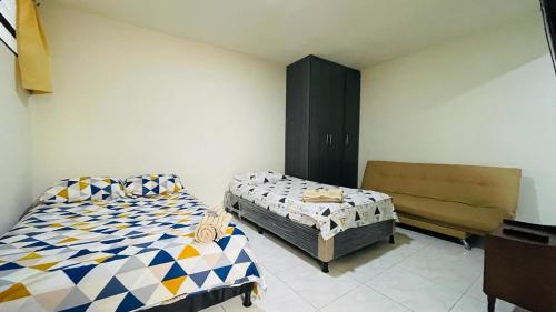 1 dormitorio con 2 camas y sofá en Aparta-estudio amoblado en Medellin, Campo Valdes, en Medellín