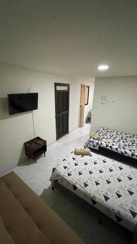 - une chambre avec 2 lits et une télévision à écran plat dans l'établissement Aparta-estudio amoblado en Medellin, Campo Valdes, à Medellín