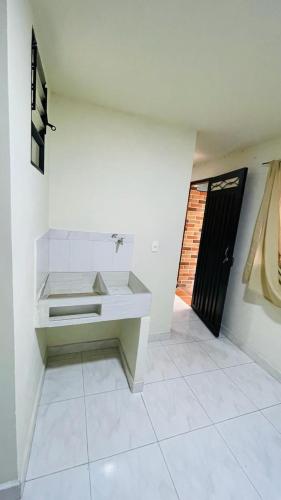Habitación blanca con banco y puerta en Aparta-estudio amoblado en Medellin, Campo Valdes, en Medellín