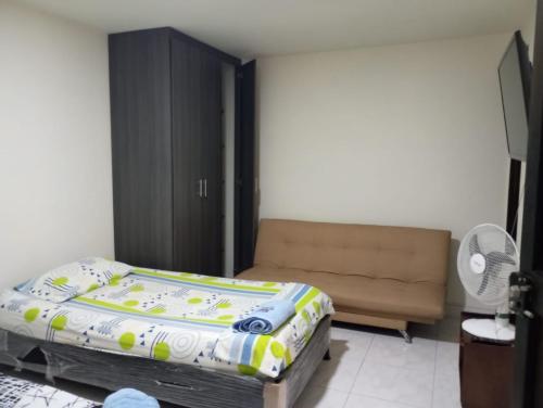 - une chambre avec un lit et un canapé dans l'établissement Aparta-estudio amoblado en Medellin, Campo Valdes, à Medellín
