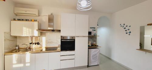 a kitchen with white cabinets and a sink at Il bacio del sole in Campomarino