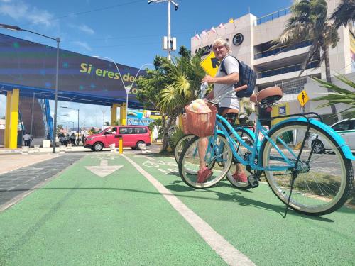 a man riding a blue bike on a street at Sunset Haven in Cancún
