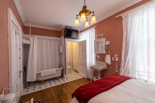 een slaapkamer met een bed, een wastafel en een spiegel bij The Convent in Brigus in Brigus