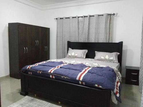 a bedroom with a bed with a blue comforter at 3 Scone Villa in Apenkwa