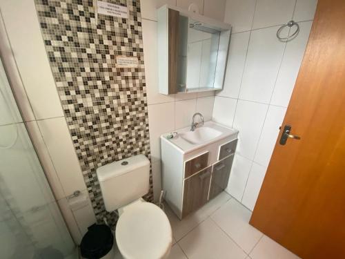 グラマドにあるResidencial Encantos da Naturezaのトイレ、洗面台、鏡のあるバスルーム