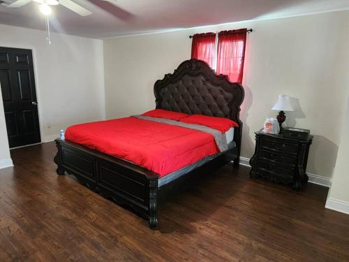 a bedroom with a large bed with a red blanket at Home lux in Louisiana in Laplace