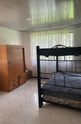 a bedroom with a bunk bed and a dresser at Casa Campestre Finca Villa Amparo in Silvania
