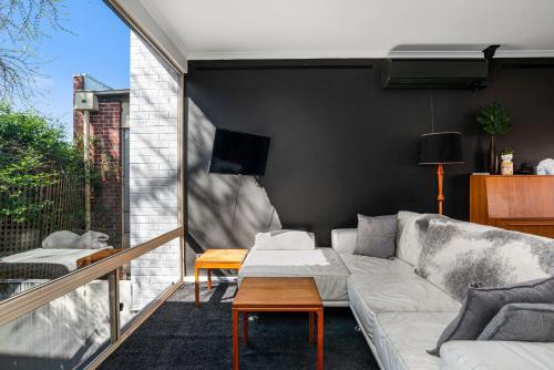 a living room with a couch on a balcony at Halifax Muse Pet Friendly Townhouse in Adelaide