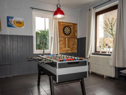 einen Spieltisch in einem Raum mit einer Uhr an der Wand in der Unterkunft Spacious mansion in Waimes with sauna in Weismes