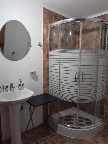 a bathroom with a shower and a sink and a mirror at Cabaña Cacique Vista Hermosa in Cochamó