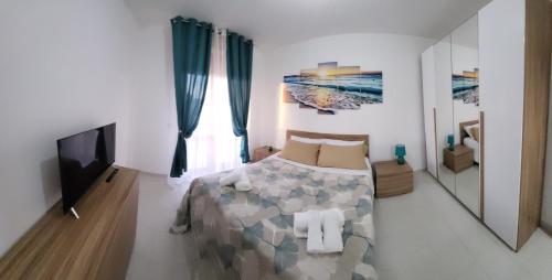 a bedroom with a bed and a flat screen tv at Il bacio del sole in Campomarino