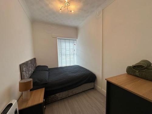 Habitación pequeña con cama y ventana en Modern & Stylish 1 bedroom flat in Bridgend town en Bridgend