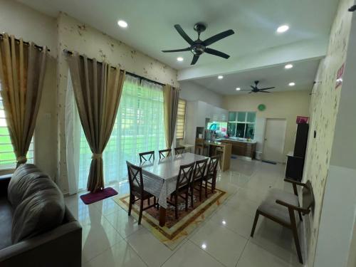 een woonkamer met een tafel en een plafondventilator bij Villa D' Manggis Melaka in Melaka