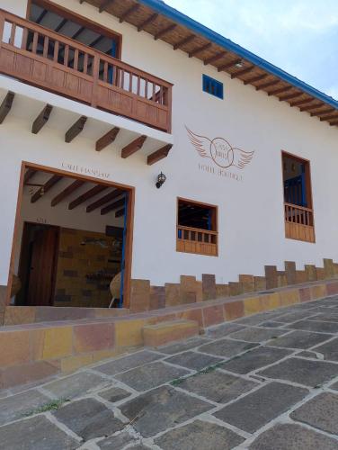 a building with a door and a balcony at Casa Iris Hotel Boutique in Barichara
