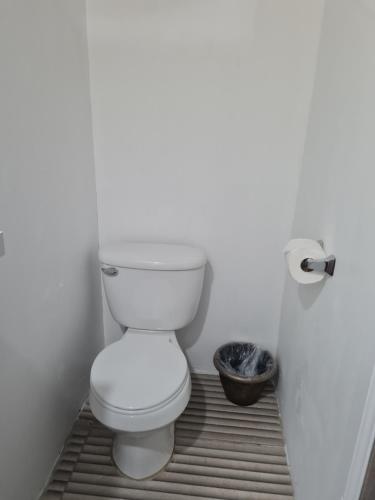 a bathroom with a white toilet in a room at Sky Beach Rooms in Lucea