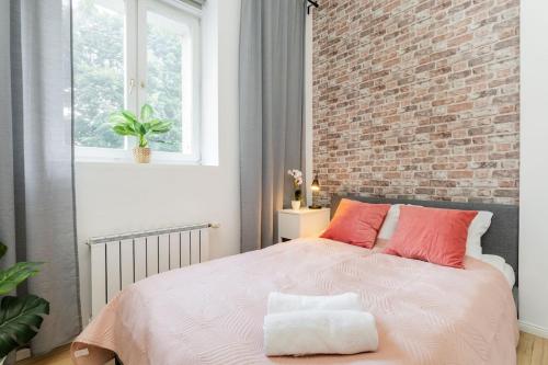 a bedroom with a large bed with a brick wall at Dragon Fruit Apartment City Center in Warsaw