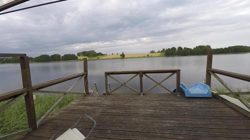 a wooden dock with a blue object on a lake at Sodyba Brazylija in Taraldžiai