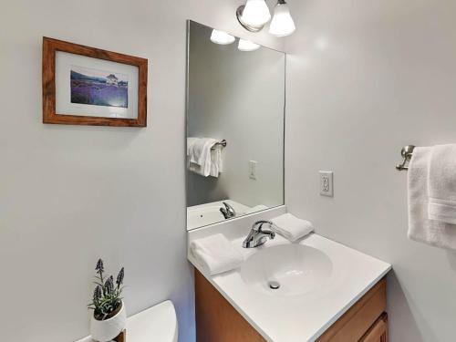 a white bathroom with a sink and a mirror at Cassiopeia in McHenry