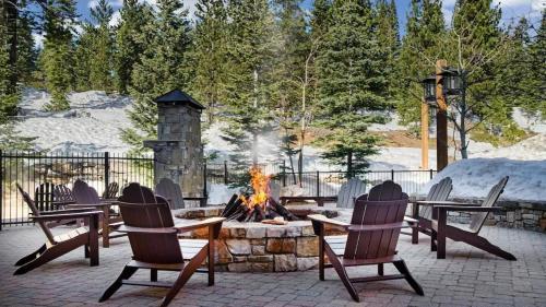 a fire pit with chairs and a table and a fire place at Spring Break! Luxurious Ski-In · Ski-Out Resort! in Truckee