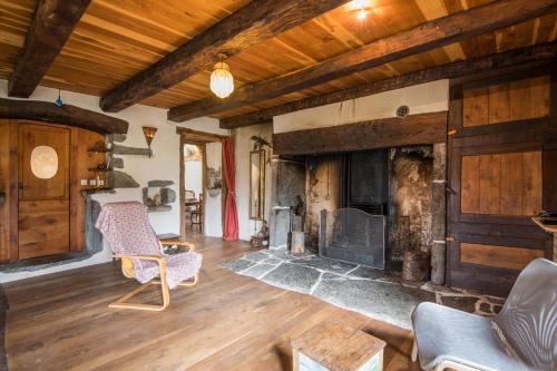 a living room with a fireplace and two chairs at Gite le Cun in Frayssinhes
