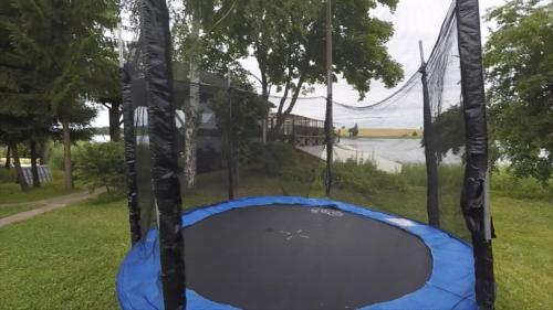 an empty trampoline in the grass with a net at Sodyba Brazylija in Taraldžiai