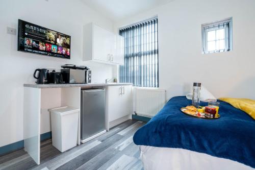 a kitchen with a bed with a plate of fruit on it at Sky rooms modern studio apartment 2 in Birmingham