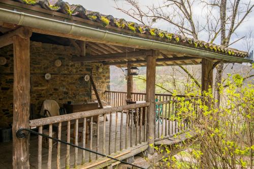 a wooden porch with a roof with birds on it at Gite le Cun in Frayssinhes