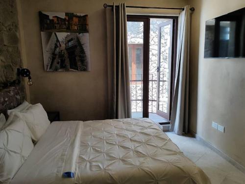 una camera con un letto e una grande finestra di Loft AMORE en Val'Quirico a Santeagueda