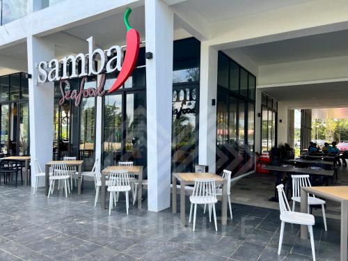 a restaurant with tables and chairs in front of a store at Roxy Sematan Beach Townhouse Deluxe 7 ,8 ,9, 10 ,11 ,12 in Sematan
