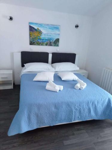 um quarto com uma cama azul com duas toalhas em Apartments with a parking space Slime, Omis - 22826 em Omiš