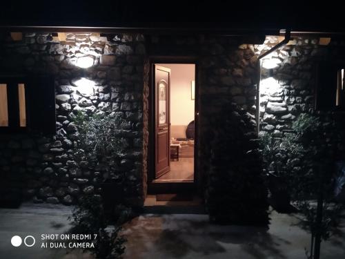 a door to a stone house at night at Το πατρικό του Σταύρου. in Mouzákion
