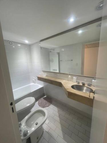 a bathroom with a toilet and a sink and a mirror at Centro Porteño in Buenos Aires