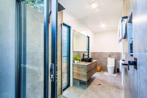 a bathroom with a shower and a toilet and a sink at Malie - Holiday studio apartment in Agnes Water in Agnes Water