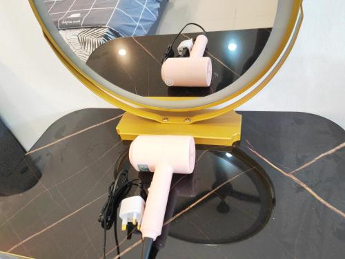 un espejo con dos rollos de cables eléctricos delante de él en Padang Serai Cozy Roomstay Share Bathroom, en Padang Serai