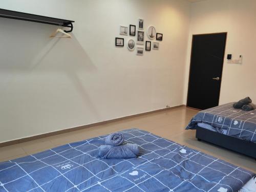 um quarto com um urso de peluche azul deitado numa cama em Padang Serai Cozy Roomstay Share Bathroom em Padang Serai