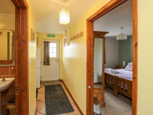 a bathroom with a sink and a bedroom at Otters Holt in North Molton